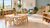 Bright daycare classroom with child-size tables, cubby storage, reading area and pretend-play furniture
